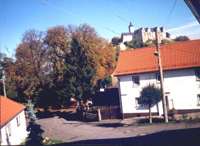 Herbstliche Straße, oben auf dem Berg die Burg
