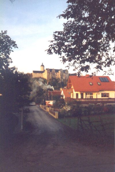 Weg in den Ort, im Hintergrund die Burg