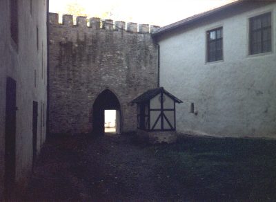 Burghof mit Zinnenmauer und Torbogen