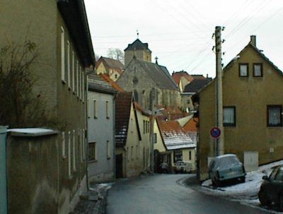 Verschneite Straße mit Blick auf die Kirche